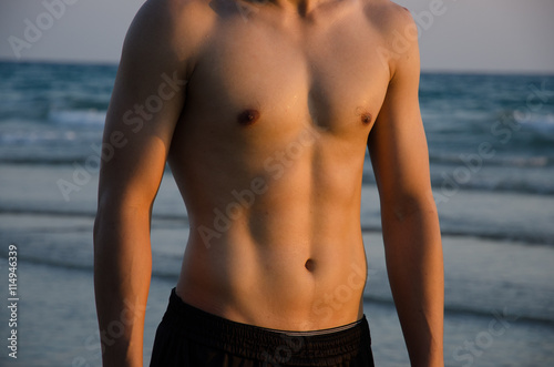 Torso of strong man against sunset