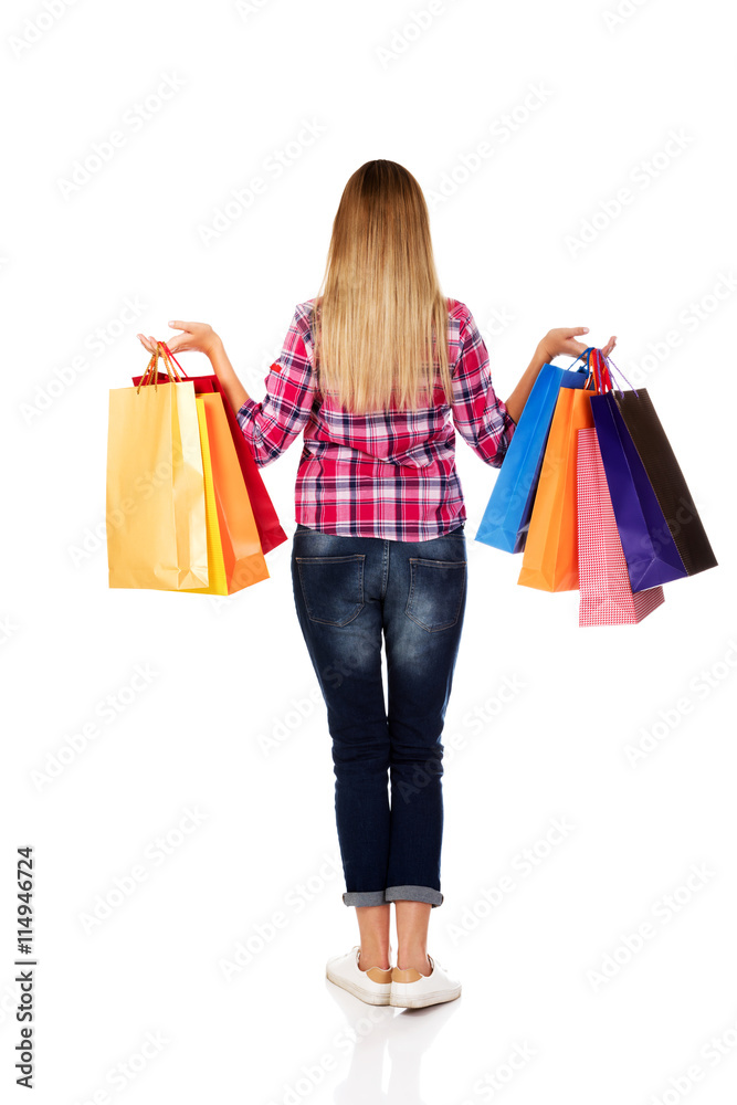 Back view of going woman with shopping bags