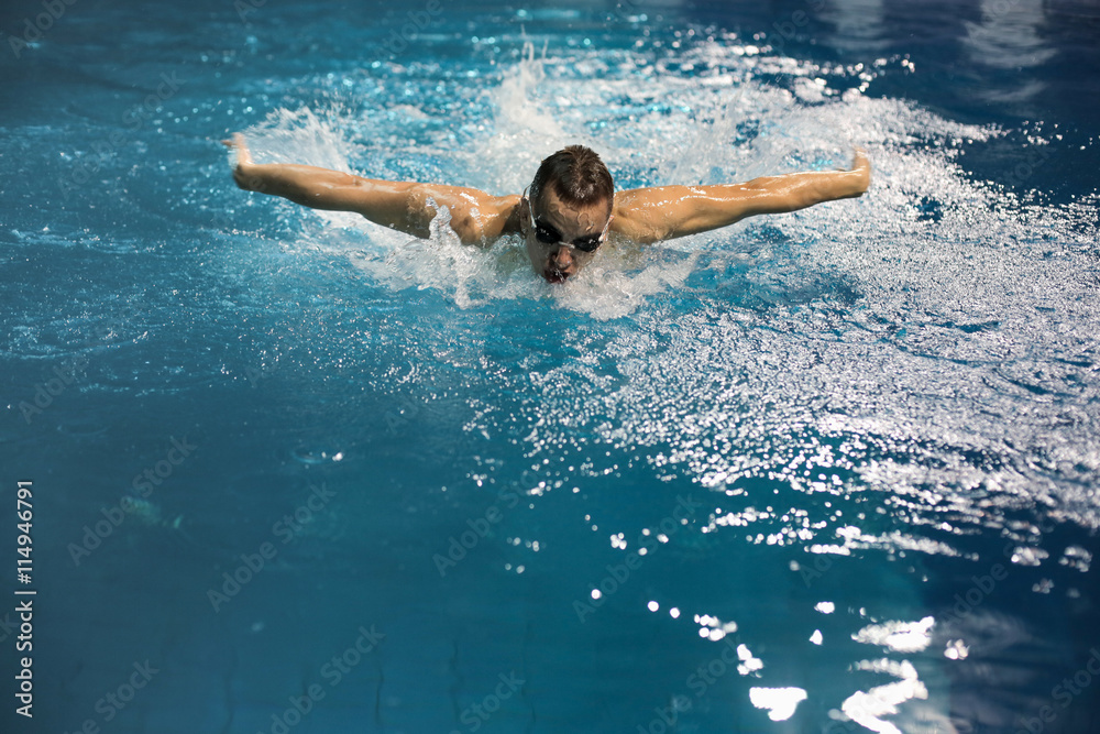 Male swimmer at the swimming pool. Underwater photo