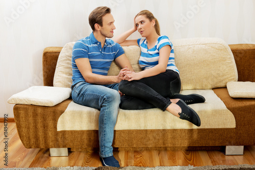 Smiling loving couple sitting on couch