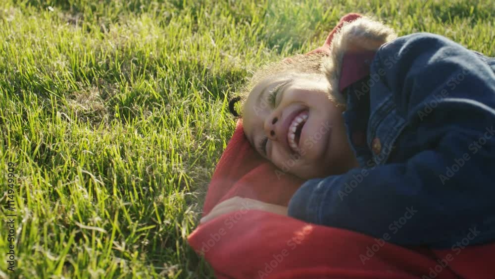 4K Young girl on a blanket on grass laughing wildly, in slow motion 4K Young girl on a blanket on grass laughing wildly, in slow motion