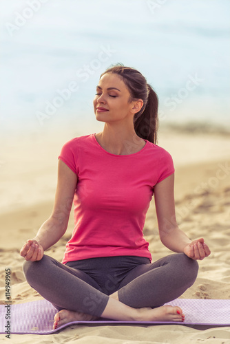 Girl doing yoga on the beach