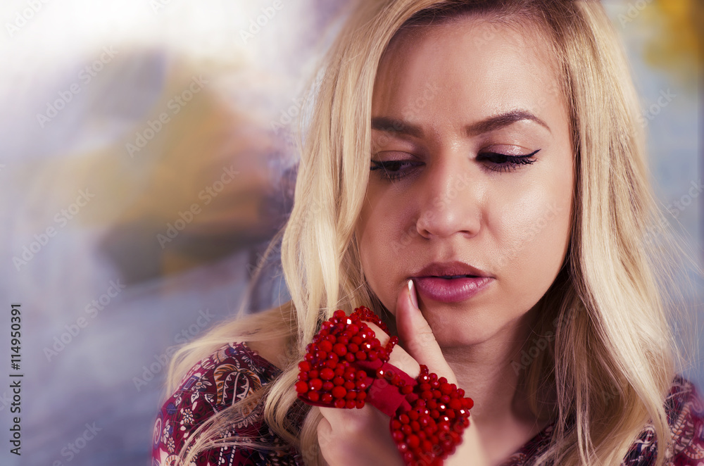 Fashion portrait beautiful blonde holding red handmade bow Fashion portrait beautiful blonde holding red handmade bow