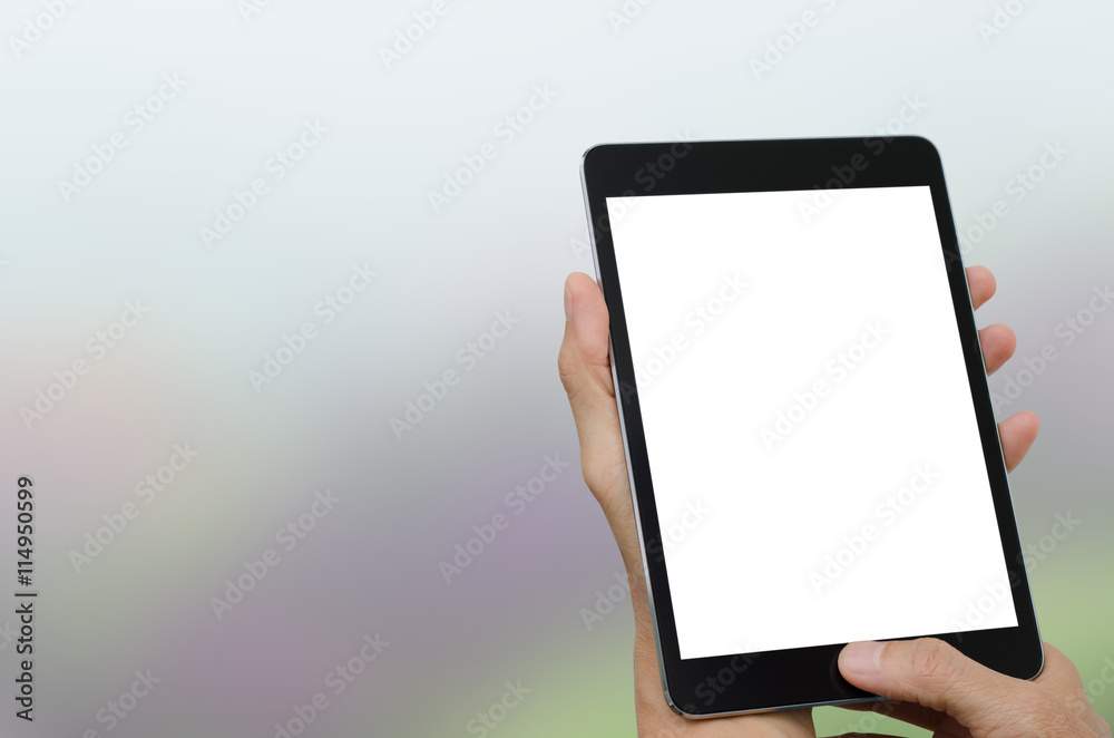 Man holding white isolated screen computer tablet with blurred background Man holding white isolated screen computer tablet with blurred background