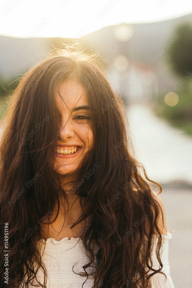 Portrait of a brunette young girl smiling at the camera