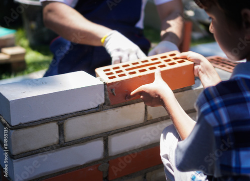 Little boy learning brick layng