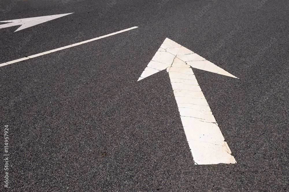 directional arrow sign painted on road surface