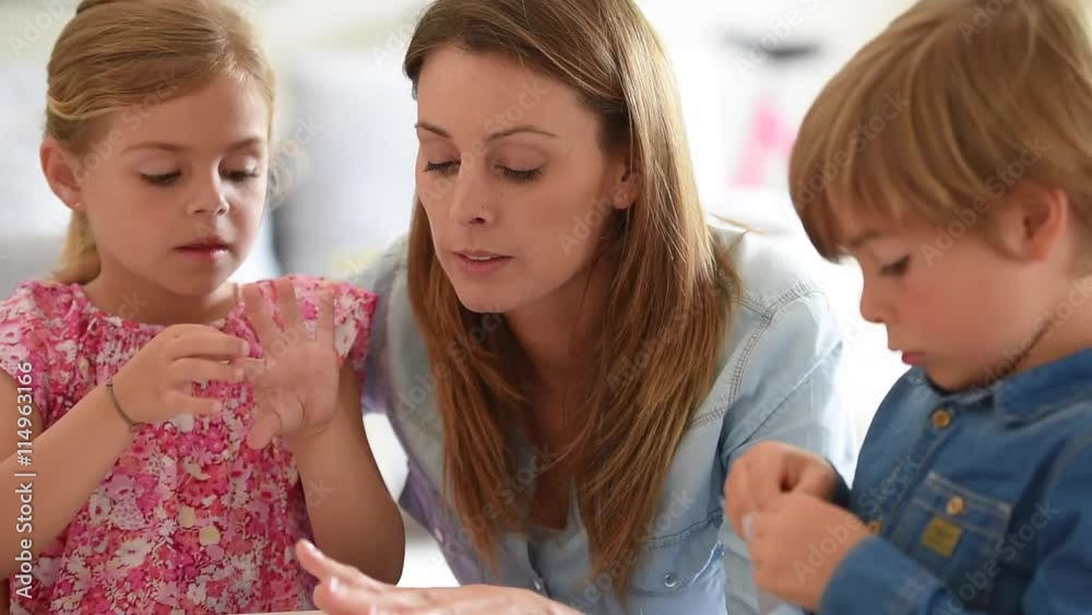 Kids and mother playing with stickers