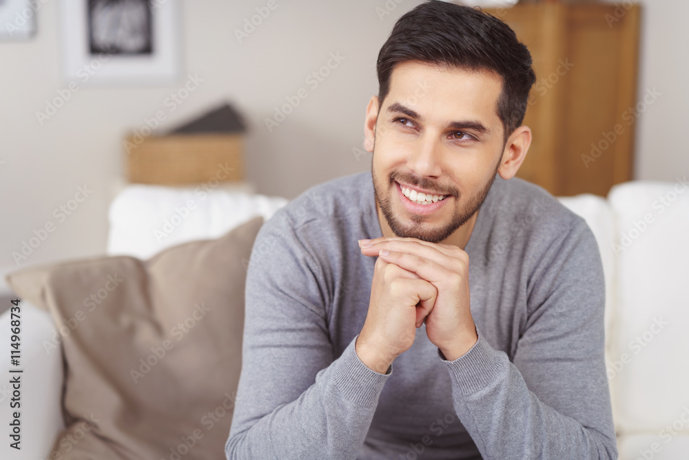 lächelnder mann sitzt auf dem sofa in seiner wohnung lächelnder mann sitzt auf dem sofa in seiner wohnung