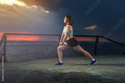Fit woman stretching legs before workout