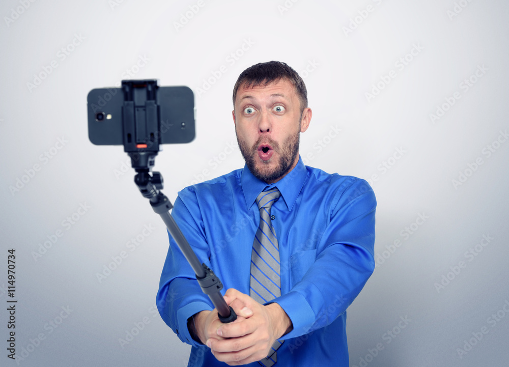 Funny bearded man in tie making selfie with a stick Funny bearded man in tie making selfie with a stick