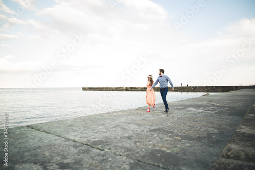Wedding couple, bride, groom walking and posing on pier