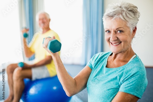Seniors using exercise ball and weights