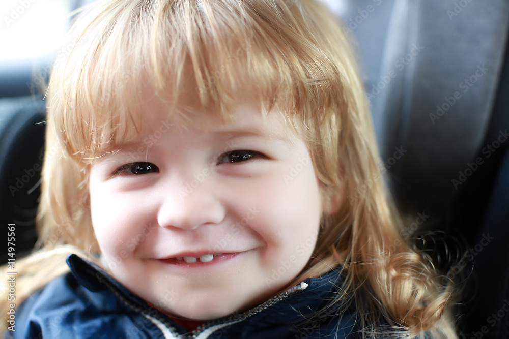 small boy smiling in car