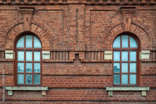 Two windows with an arch on the background wall of brown brick. From the series window of Saint-Petersburg.