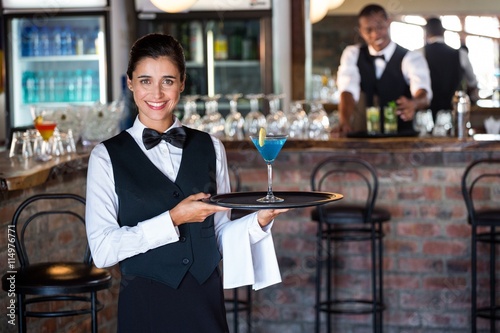 bartender holding serving tray with glass of cocktail