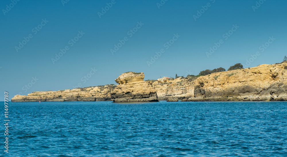 A view of cliff on the Algarve coast from a boat sailing on the sea in Portugal, 2016