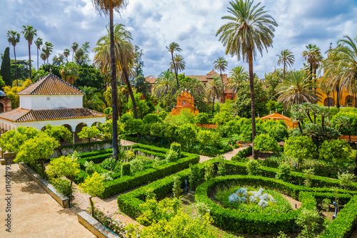 Romantic public garden of Seville palace in a day time. Traditional medieval design inside a Royal Palace of Andalusia, Spain