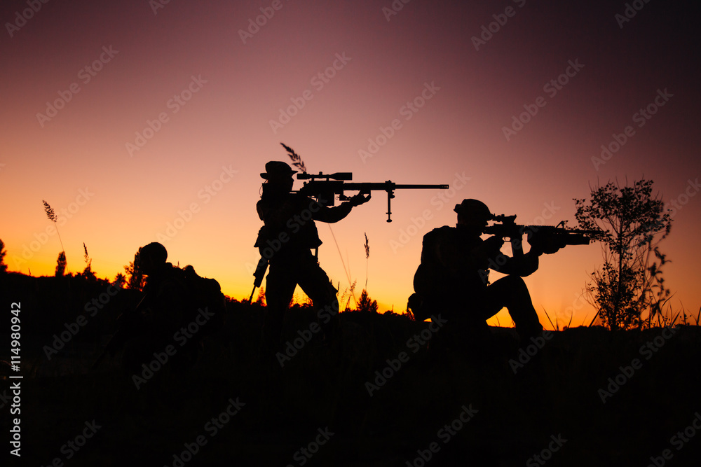 Silhouette of military soldiers with weapons at night. shot, hol Silhouette of military soldiers with weapons at night. shot, hol