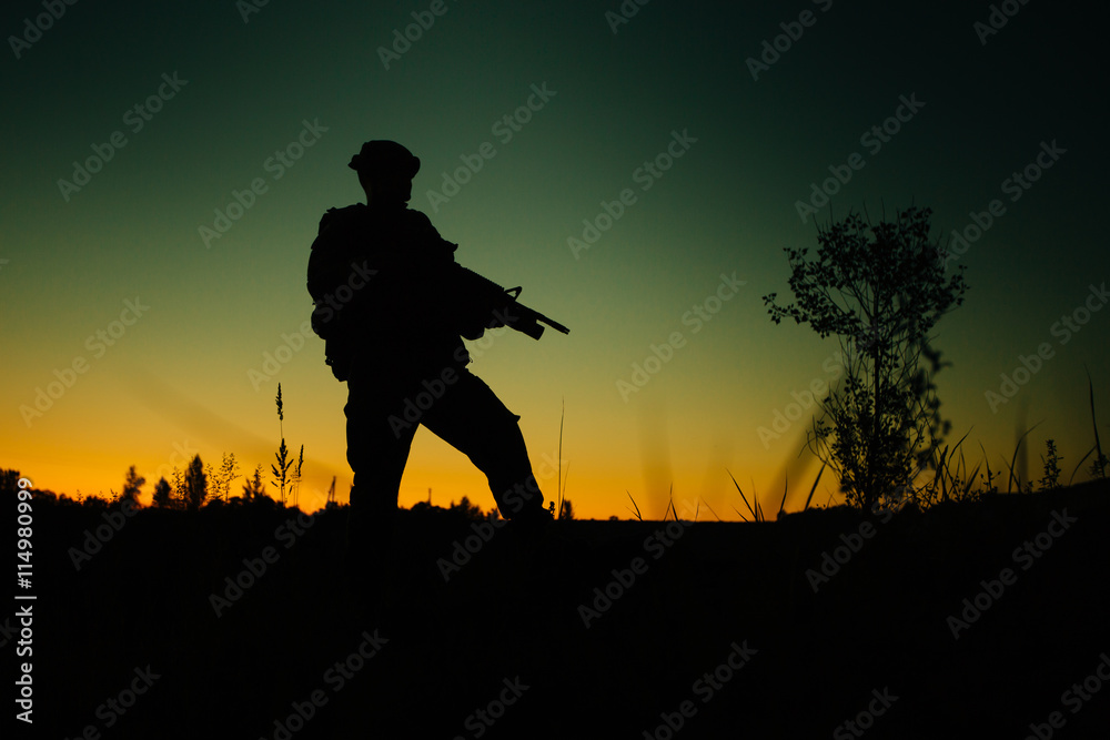 Silhouette of military soldier or officer with weapons at night.