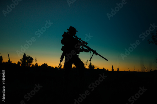 Silhouette of military soldier or officer with weapons at night.