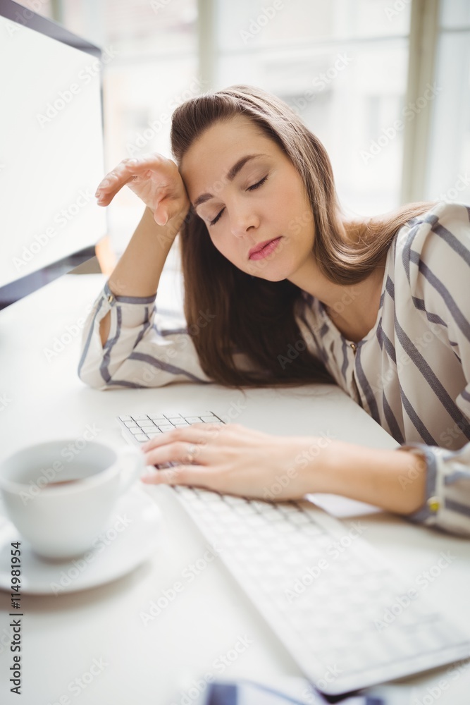 Businesswoman taking nap while working in creative office