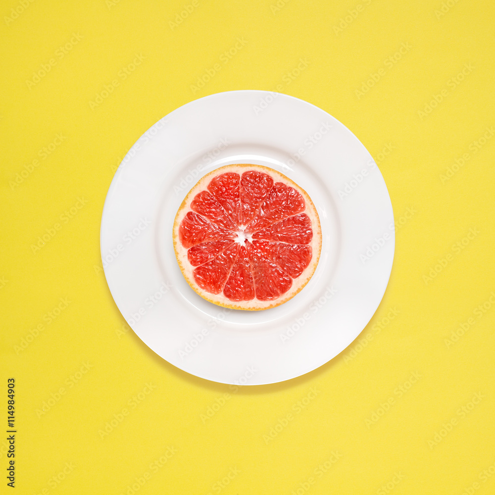 Grapefruit for breakfast / Red grapefruit slice on white plate on yellow background. Grapefruit for breakfast / Red grapefruit slice on white plate on yellow background.