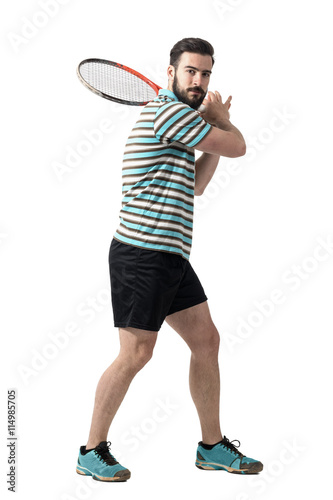 Tennis player waiting to hit ball holding racket with both hands in backhand pose. Full body length portrait isolated over white studio background. © sharplaninac