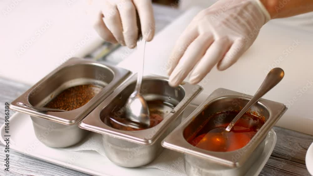 Spoon mixes liquid with meat. Hand puts meat into sauce. Special sauce for veal. Restaurant chef working with meat. Spoon mixes liquid with meat. Hand puts meat into sauce. Special sauce for veal. Restaurant chef working with meat.