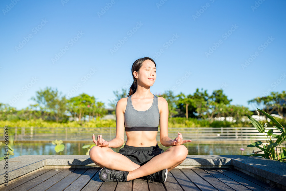Woman sitting in yoga pose at park