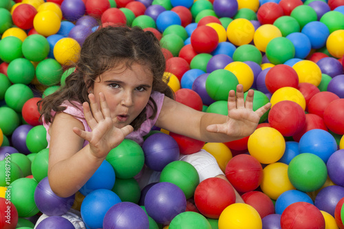 Girl having fun playing in a colorful plastic ball pool