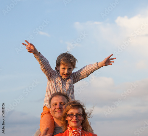 Happy family: father, mother and son have fun outdoor 