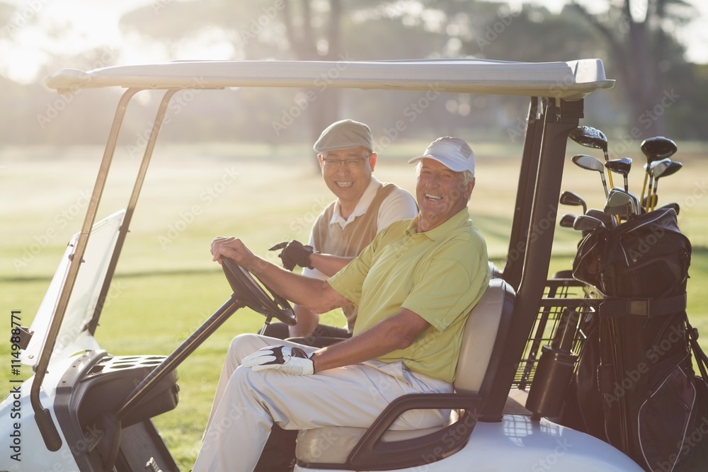 Portrait of cheerful golfer friends sitting in golf buggy Portrait of cheerful golfer friends sitting in golf buggy