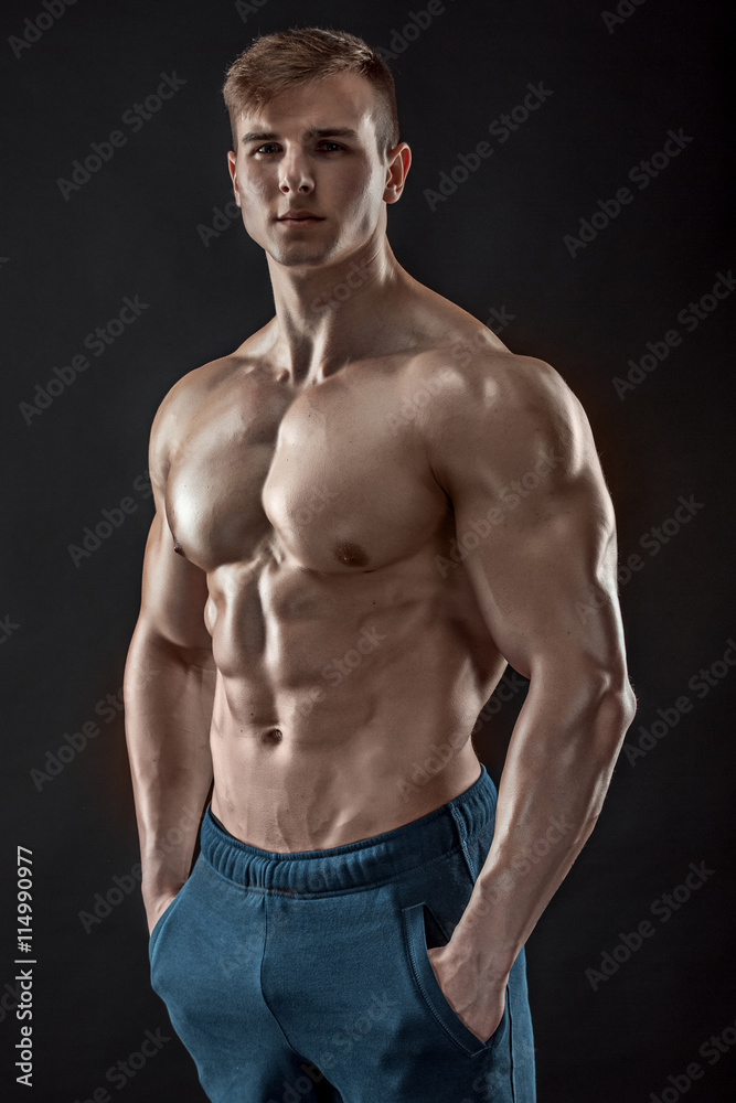 Muscular bodybuilder guy doing posing over black background Muscular bodybuilder guy doing posing over black background
