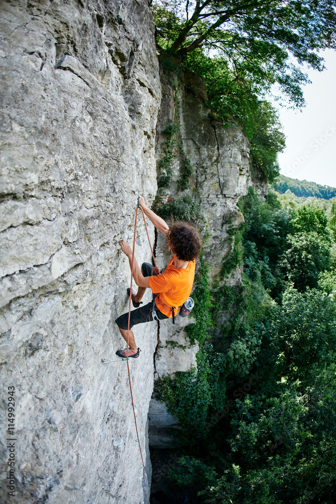 male rock climber. rock climber climbs on a rocky wall. man makes hard move male rock climber. rock climber climbs on a rocky wall. man makes hard move