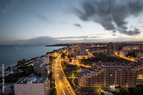City at the bank of the ocean during sunset. photo
