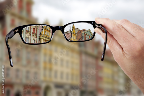 Hand holding glasses to see clearly