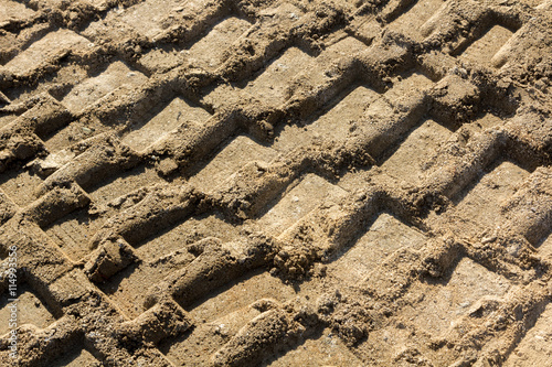 Background with footprints in the sand of heavy machinery