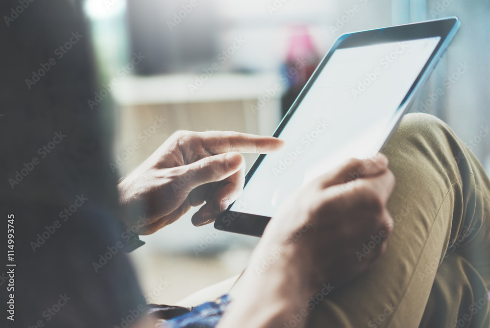 Marketing brand manager reading business news modern Interior Design Loft Office.Man relax Vintage Sofa,Use contemporary tablet,share information.Blurred Background.New Startup Idea Process Closeup