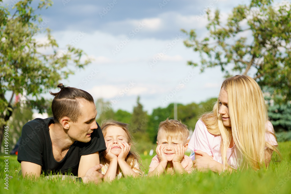 Portrait of happy parents with kids lying at the park Portrait of happy parents with kids lying at the park