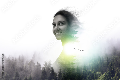 Fotografi Double exposur portrait of smiling woman and trees
