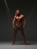 Young naked man, muscular body, bounded with rope