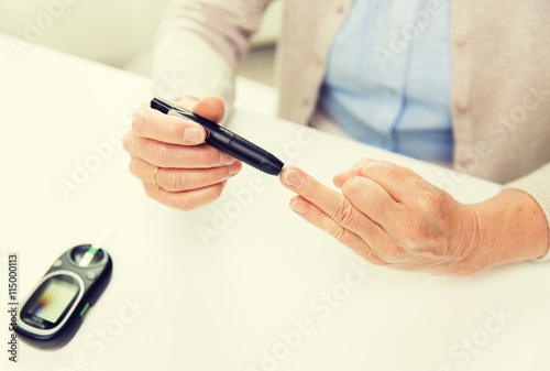 senior woman with glucometer checking blood sugar