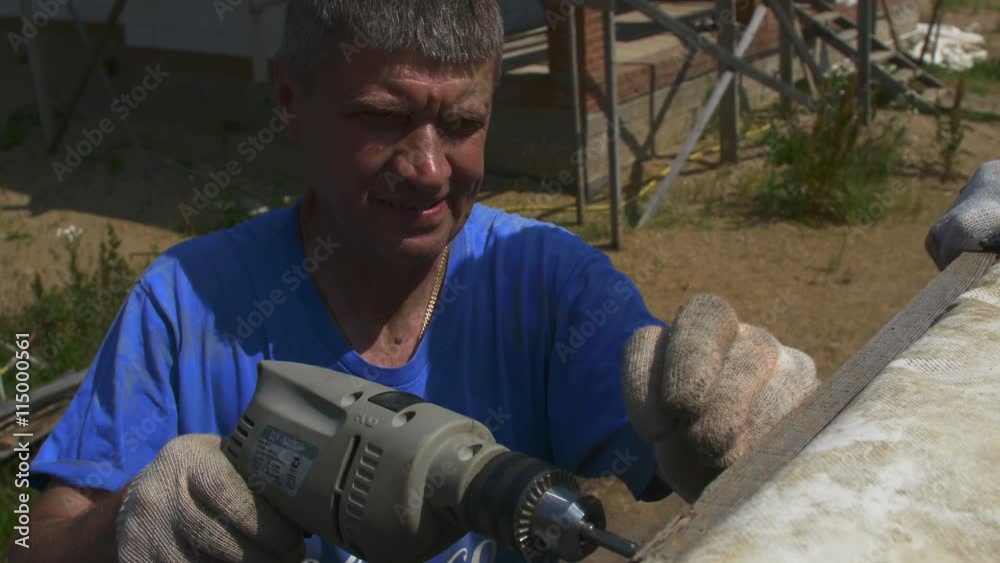 A man tightening the bolt with a drill A man tightening the bolt with a drill