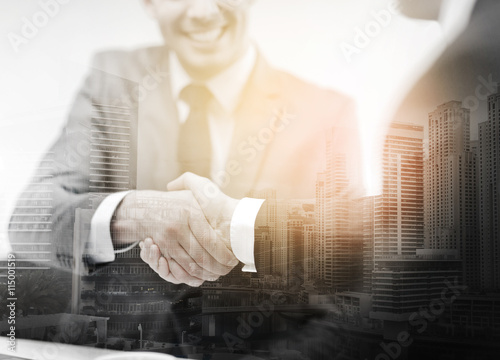 two businessmen shaking hands in office photo