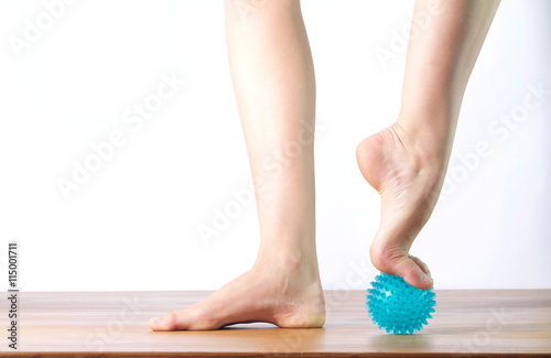ballet dancer massage the forefoot with a ball