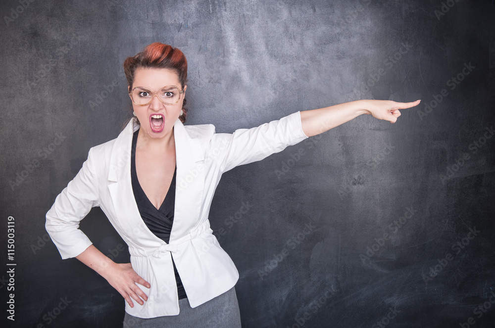 Angry screaming teacher pointing out blackboard background