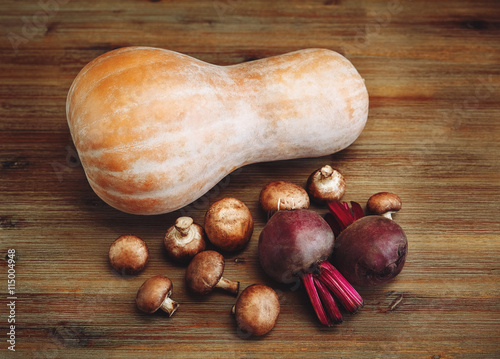 Purple Beets,Pumpkin,Fresh Mushrooms on the Wooden Table.Autumn Garden's Vegetable Background.Top View photo