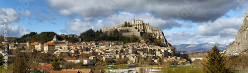 Fotografia Panoramic view of Sisteron rooftops and the Citadel in summer light with clouds