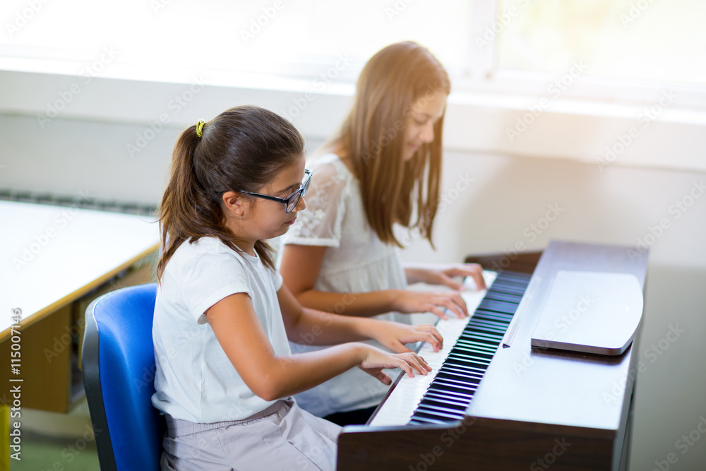 Fototapeta Dwie dziewczyny grające na pianinie w szkole muzycznej, selektywne skupienie